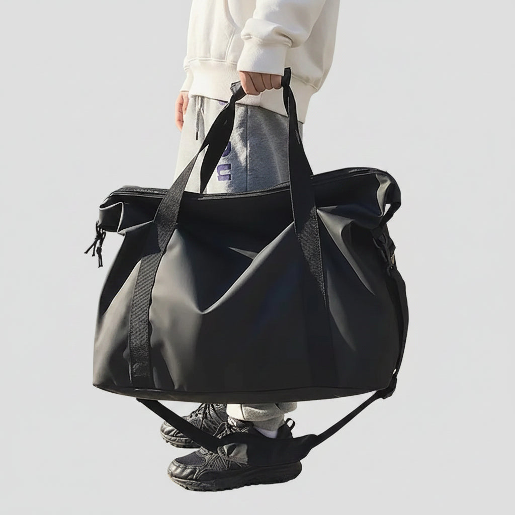 Sac de voyage souple noir porté à la main