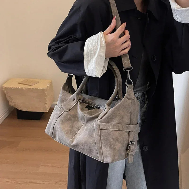 Sac bandoulière aspect cuir rétro kaki porté à l'épaule