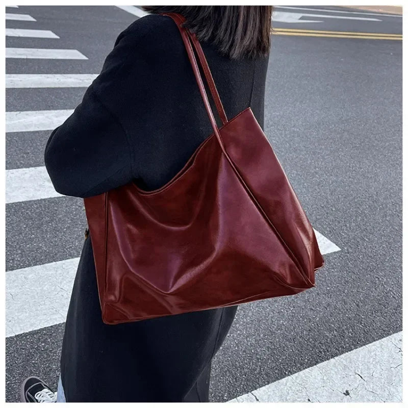 Sac seau aspect cuir souple bordeaux porté à l'épaule