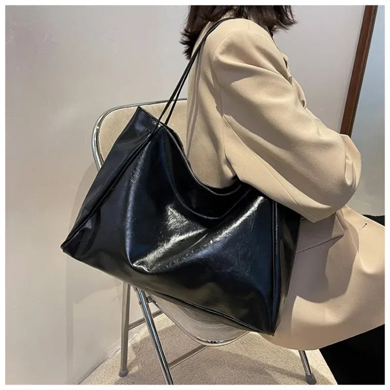 Sac seau aspect cuir souple noir porté à l'épaule
