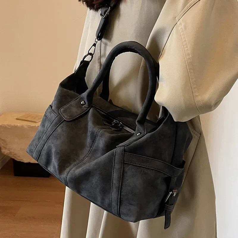 Sac aspect cuir rétro noir texturé porté à l'épaule avec la bandoulière