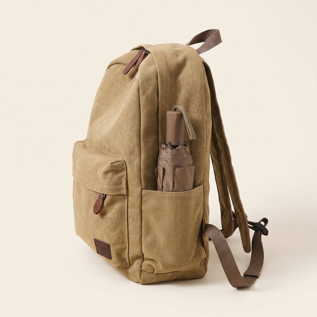 Sac à dos toile canvas kaki de profil, parapluie dans la poche latérale