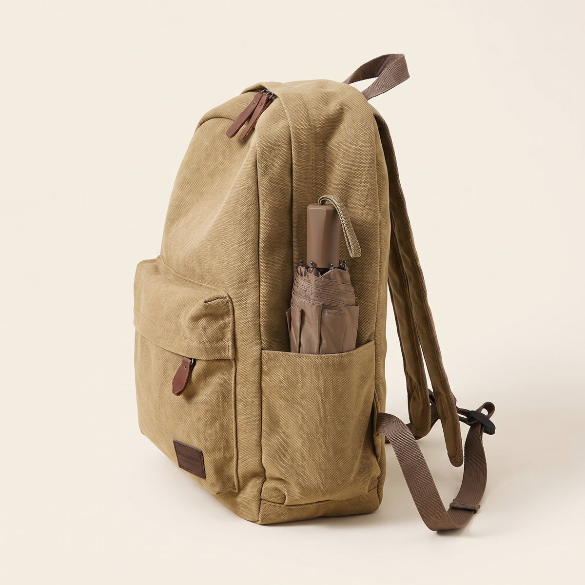 Sac à dos toile canvas kaki de profil, parapluie dans la poche latérale