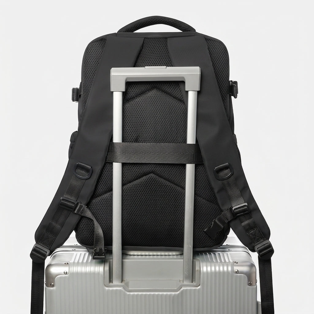 Sac à dos compression noir vu de dos, glissé sur la poignée d'une valise