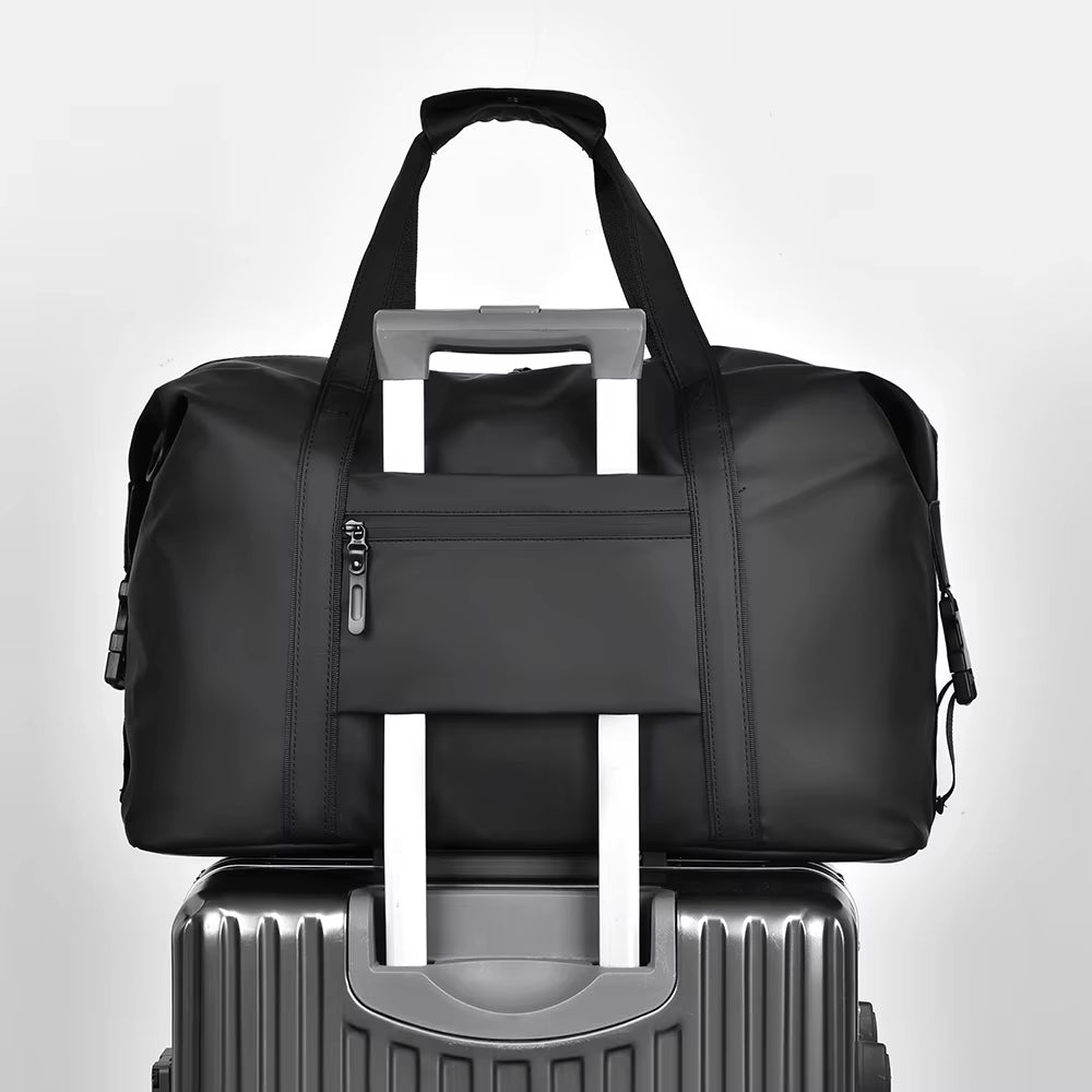 Sac de voyage homme noir glissé sur la poignée d'une valise