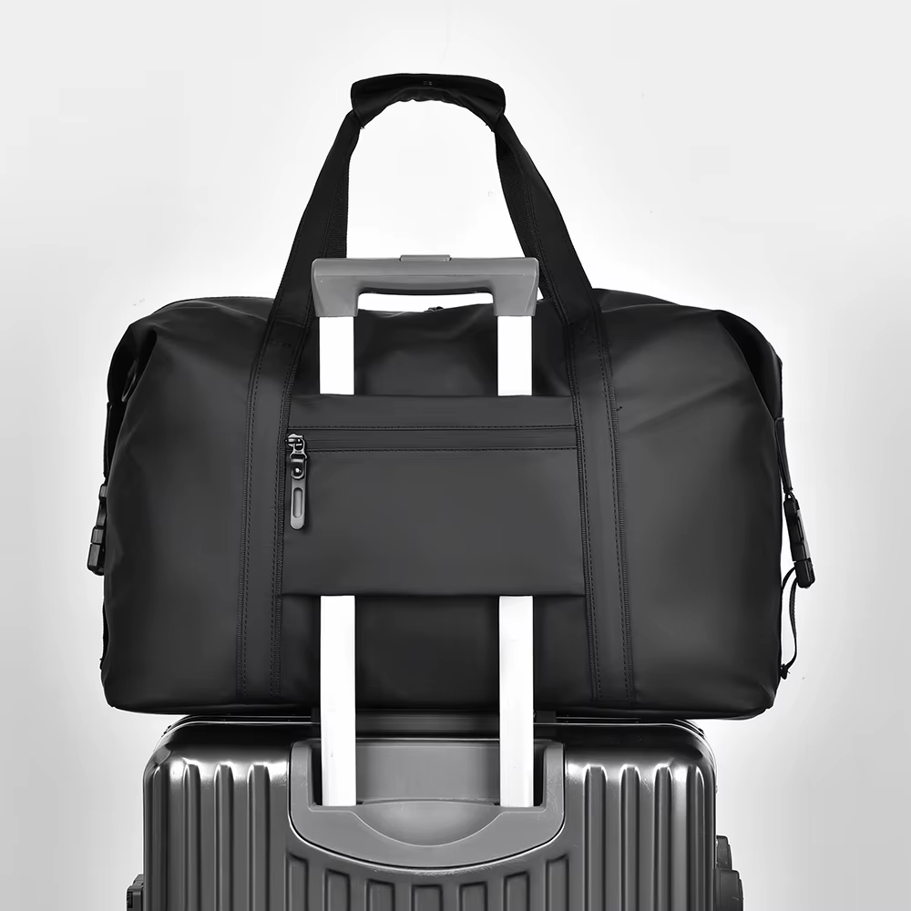 Sac de voyage homme noir glissé sur la poignée d'une valise