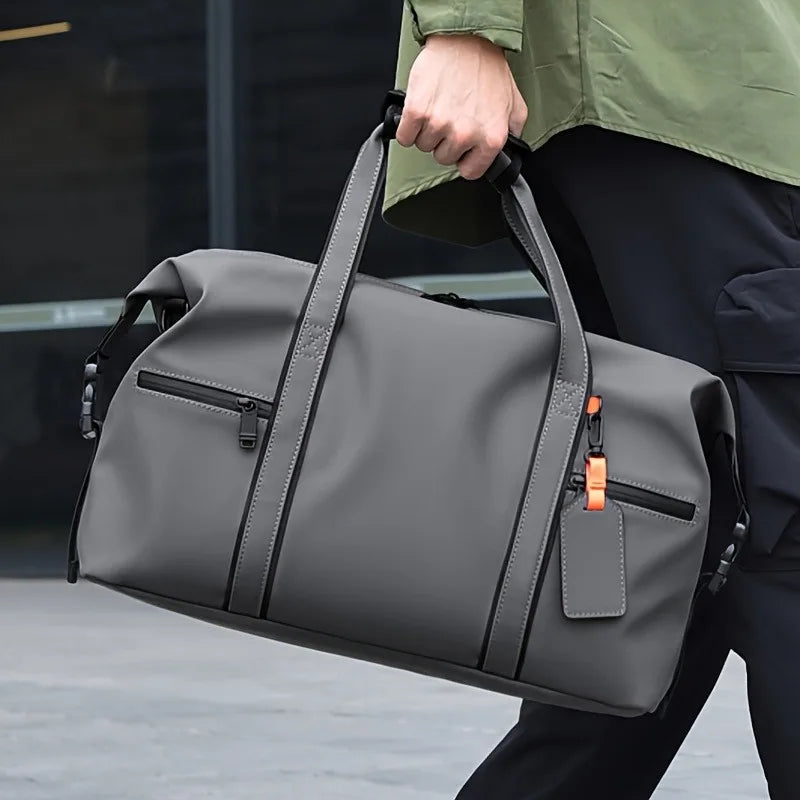 Homme portant le sac week-end aspect cuir gris à la main