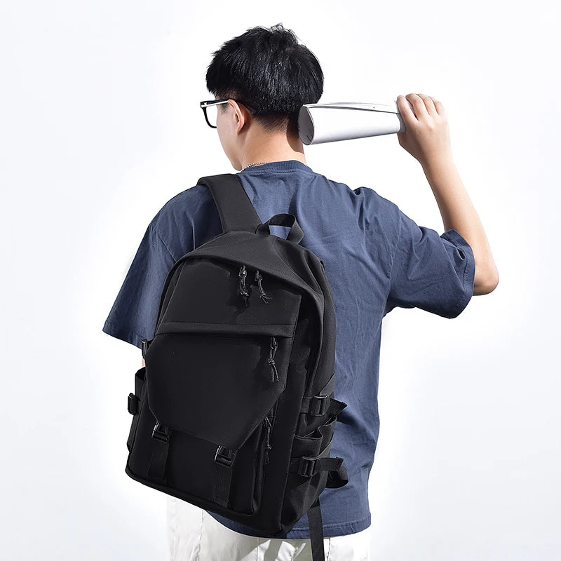 Sac à dos noir porté de dos, rabat avant zippé et boucles de serrage latérales