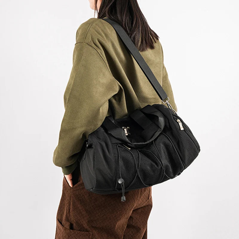 Femme portant le sac de sport noir en bandoulière