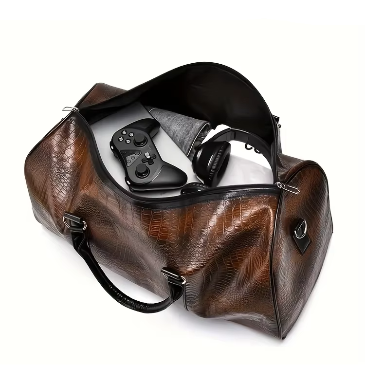 Sac polochon effet croco marron ouvert – vêtements, casque et manette à l'intérieur