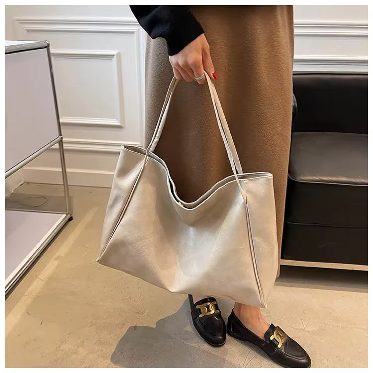 Sac seau aspect cuir souple blanc crème porté à la main