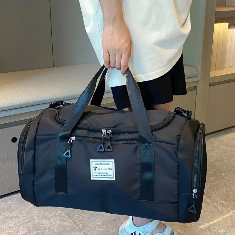 Sac de voyage pliable noir porté à la main