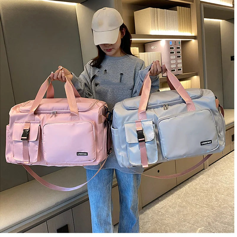 Femme tenant deux sacs week-end convertibles, dont un bleu