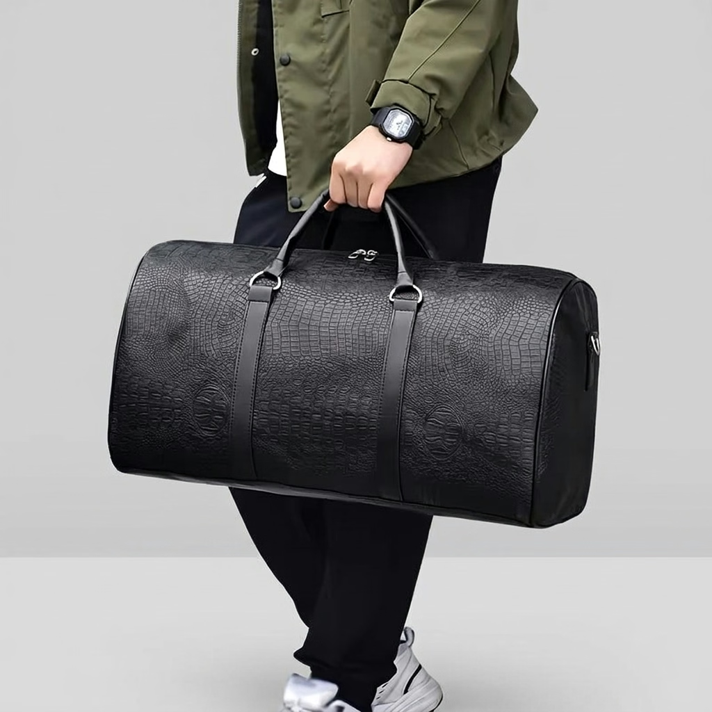 Sac polochon effet croco noir porté à la main, vue de côté