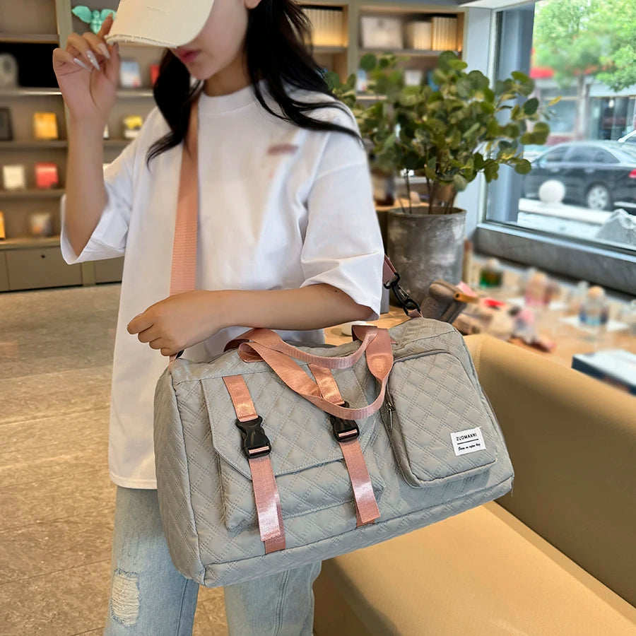 Femme portant le sac de voyage en nylon gris et rose à l'épaule