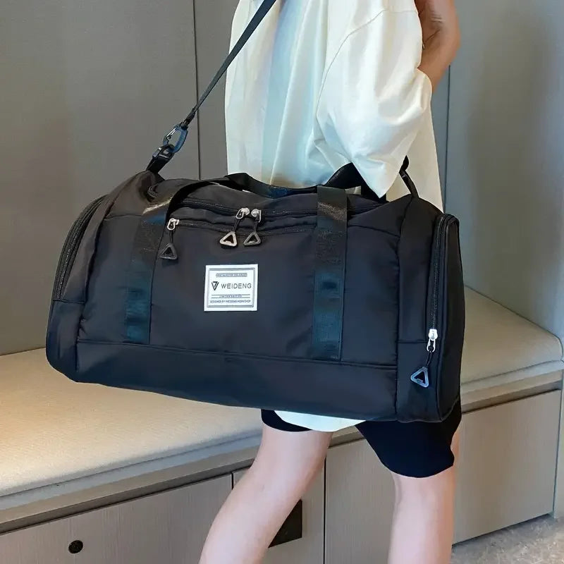 Sac de voyage pliable noir porté en bandoulière