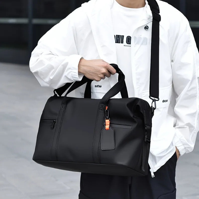 Homme portant le sac week-end aspect cuir en bandoulière