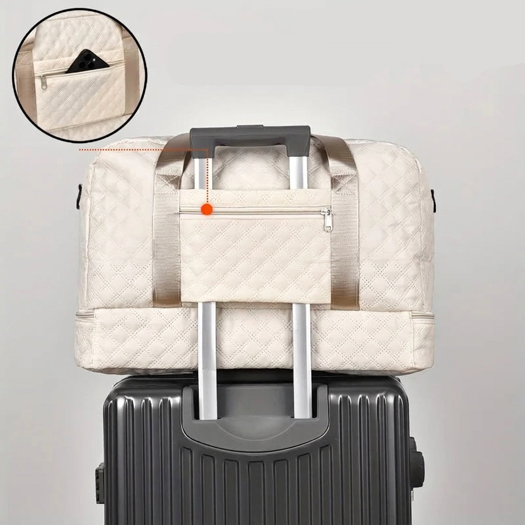 Grand sac week-end matelassé posé sur une valise, vue de la poche arrière